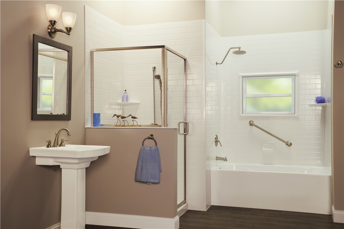 Bathroom with white subway tile shower, textured taupe walls, pedestal sink, grab bar, and dark wood floor.