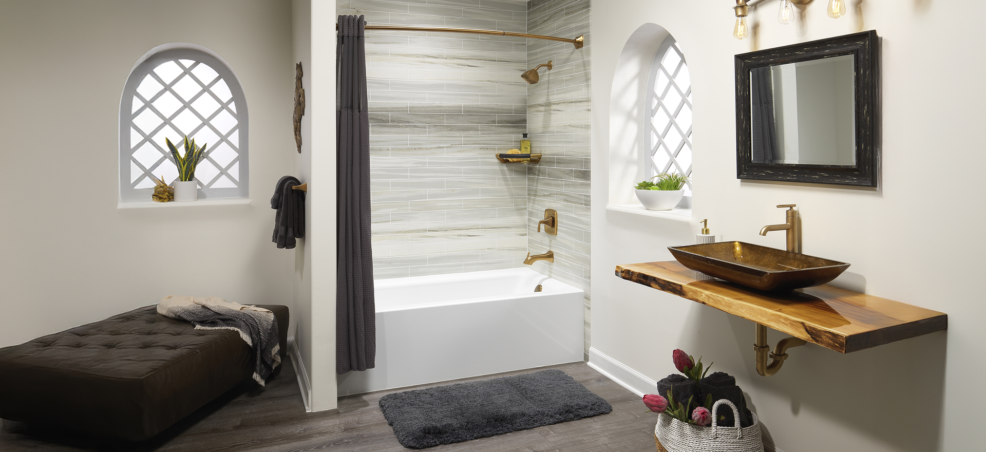 Modern bathroom with a bathtub, gold fixtures, a vessel sink on a wooden countertop, gray floors, and arched windows with lattice detailing.
