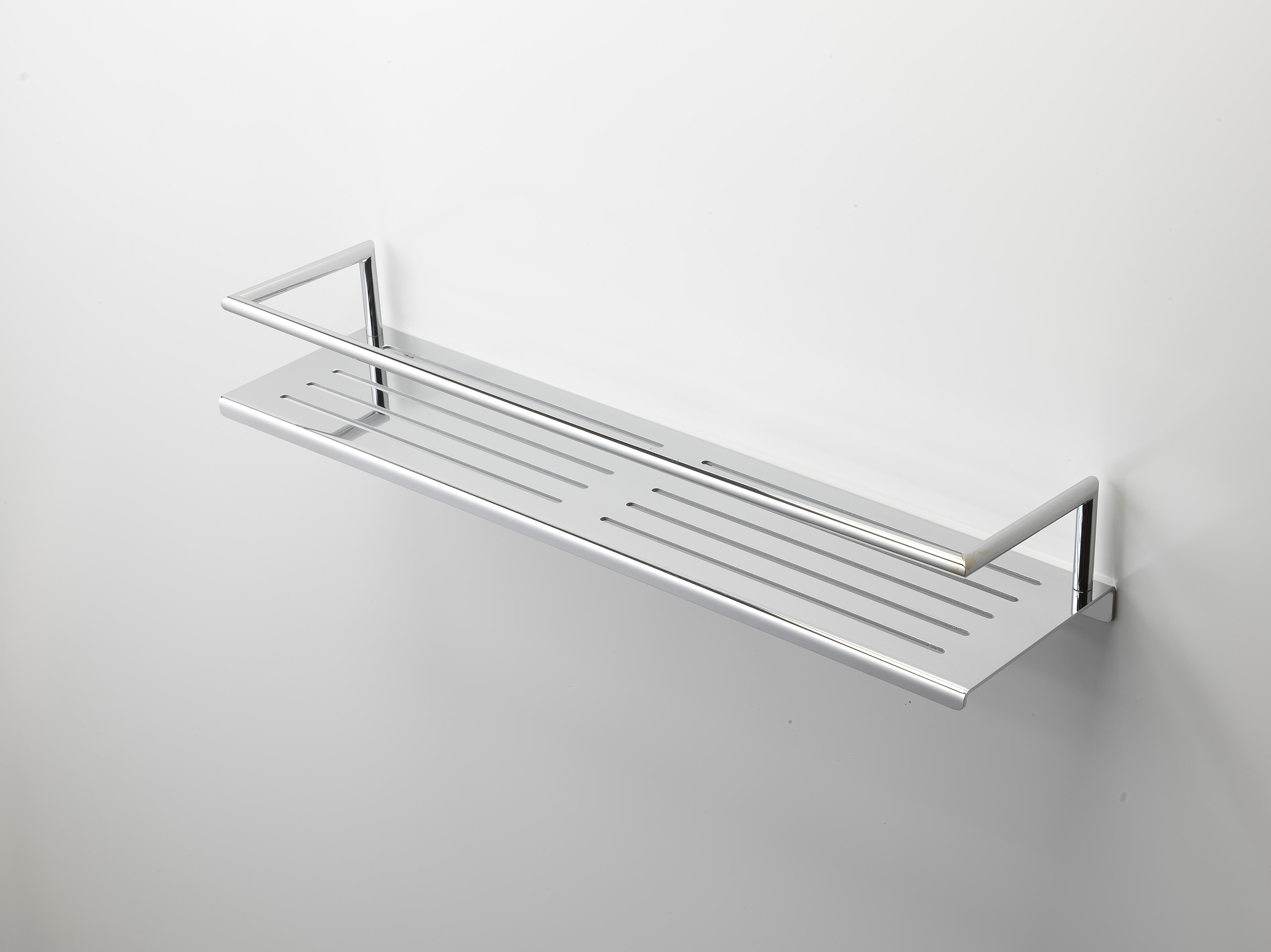 A metallic wall shelf with slotted lines is mounted on a white wall in the corner of a room.