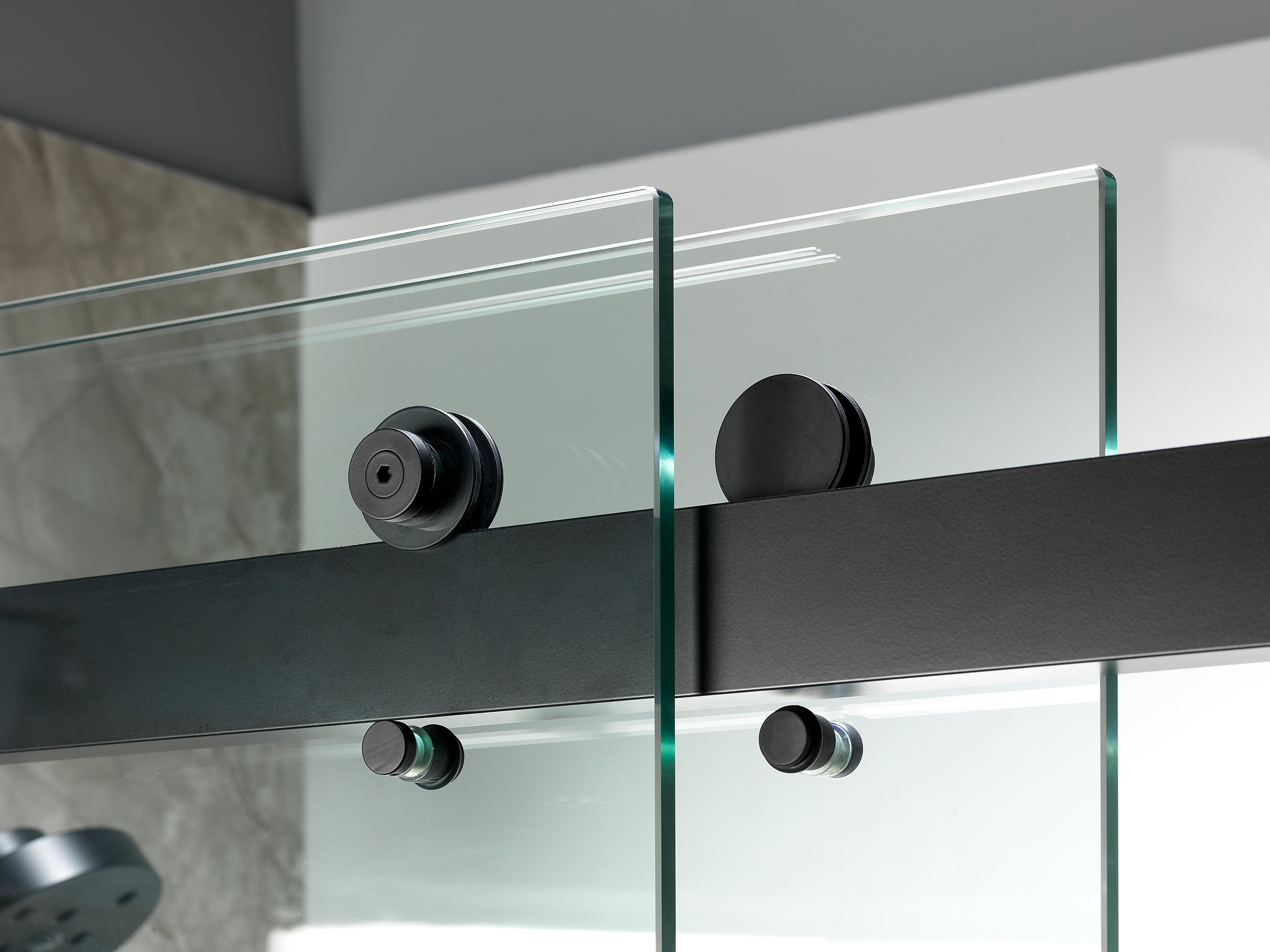 Close-up of a modern glass shower door with matte black hardware.
