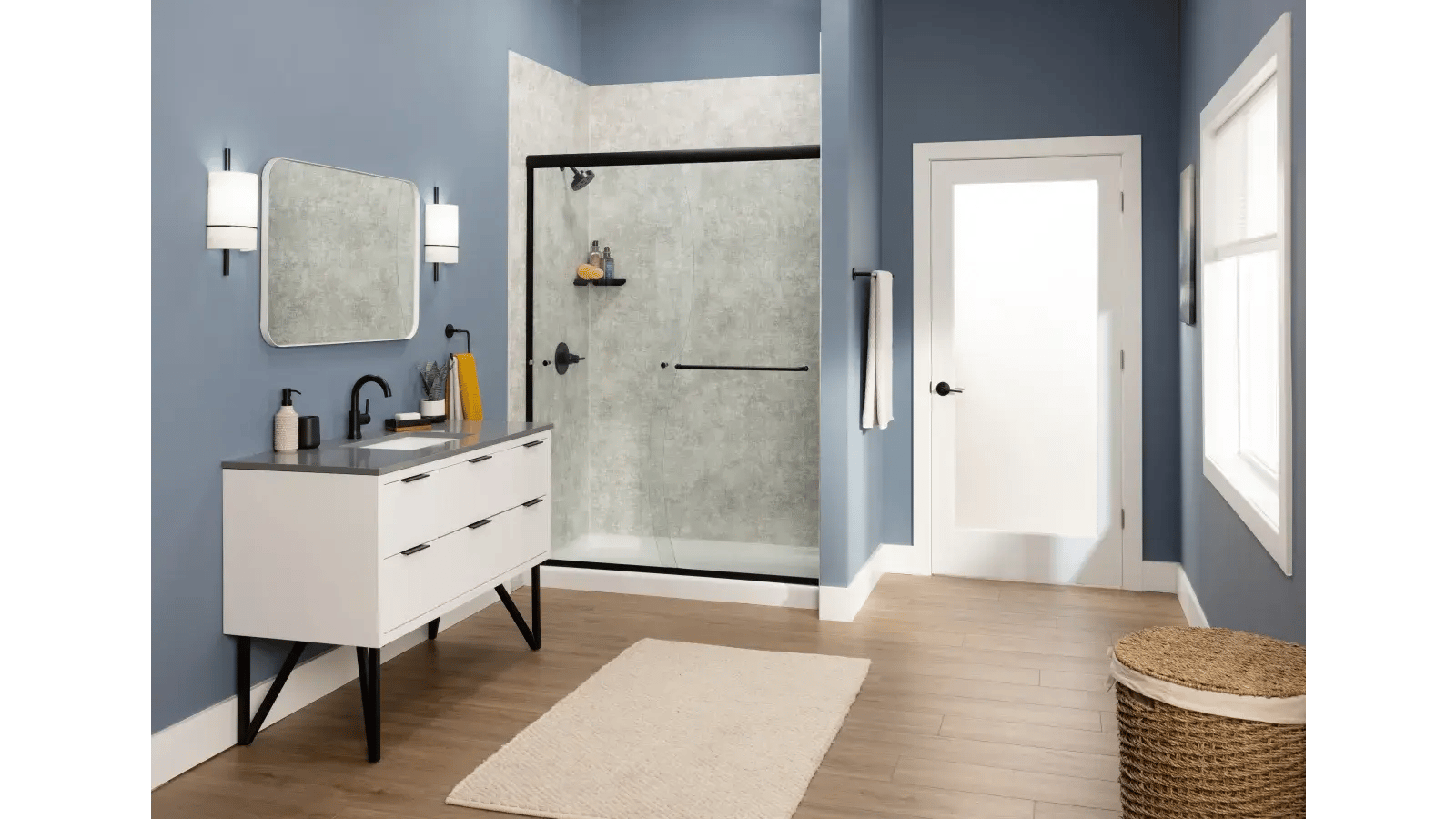 Modern bathroom interior featuring a white vanity with black hardware, a walk-in shower with gray marble-patterned walls, a white door, and blue walls.