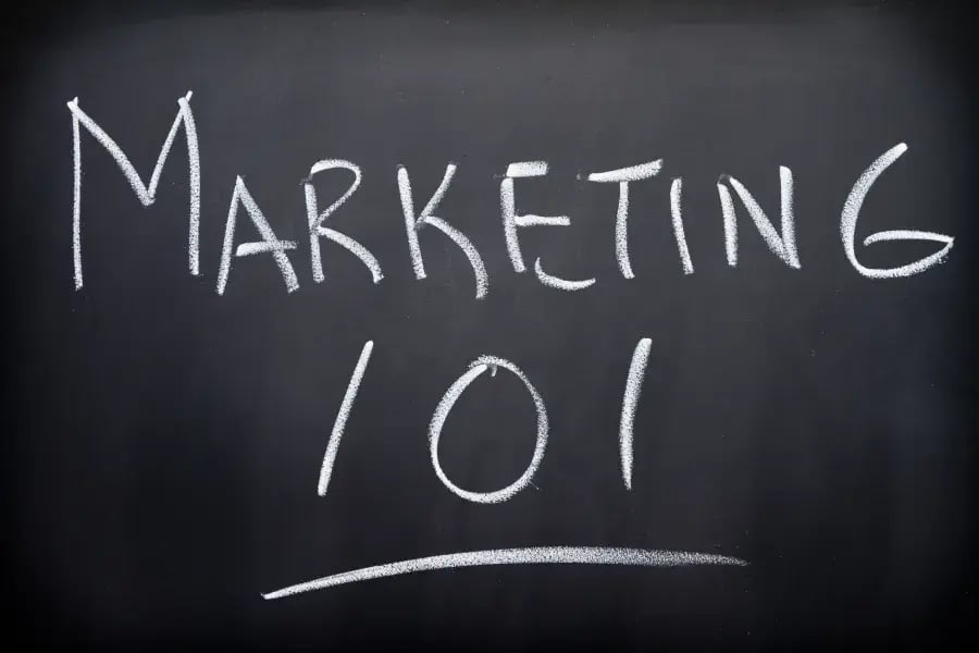 Marketing 101 written in white chalk on a blackboard.