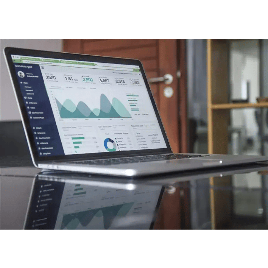 Laptop screen displaying data analytics dashboard on a reflective surface.